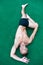 Man yoga practice pose green surface top view. Athlete doing yoga asana at green background. Practicing asana concept