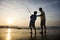 Man and young boy fishing in surf