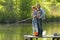 Man and young pretty girl fishing on the lake, weekend