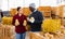 Man and young woman having conversation honeynut squashes crop in warehouse