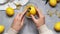 Man zesting lemon at grey table, closeup