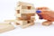 Manage risk concept with wooden blocks falling from structure