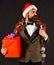 Manager with beard holds red gift. New Year decorations concept.