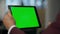 Manager hand zooming green tablet screen closeup. Man touching chromakey display