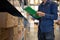 Manager man worker doing stocktaking of product management in cardboard box on shelves in warehouse. Physical inventory count..