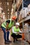 Manager and supervisor taking inventory in warehouse, male workers in uniform talking