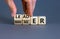 Manager versus leader symbol. Businessman flips wooden cubes and changes the word `manager` to `leader`. Beautiful grey backgr
