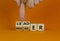 Manager versus leader symbol. Businessman flips wooden cubes and changes the word `manager` to `leader`. Beautiful orange