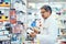 Managing medical matters in his pharmacy. Shot of a mature pharmacist using a digital tablet while working in a chemist.