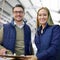 Managing operations with a smile. Portrait of a two managers reading paperwork while standing on the factory floor.