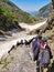 Manali, India - June 15th 2019: A group of hikers from a trekking club, climbing down a glacial valley of Indian Himalayan Mountai