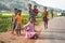 Manandoana, Madagascar - April 26, 2019: Group of unknown Malagasy kids playing on road next to rice field, small hills in