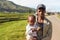 Manandoana, Madagascar - April 26, 2019: Unknown Malagasy man holding child with piece of food on his hand, rice fields in