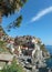 Manarola on a hot summer day under blue sky with a white cloud