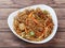 Manchurian Noodles a popular indo-chinese dish served over a rustic wooden background, selective focus