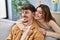 Mand and woman couple hugging each other sitting on sofa at home