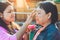 MANDALAY-Myanmar, January 20, 2019 : Female tourist guide paints tanaka powder on female tourist face while traveling on boat on