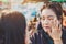 MANDALAY-Myanmar, January 20, 2019 : Female tourist guide paints tanaka powder on female tourist face while traveling on boat on