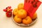 Mandarin oranges in basket with Chinese New year red packets and lion doll