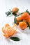 Mandarine or clementine with leafs on wooden table, winter fruits