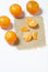 Mandarins are laid out on a white surface. Next to them is peeled mandarin on a piece of linen. Visible slices of mandarin. On