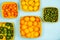 Mandarins, lemons, limes, calamansis and oranges in yellow baskets over a light blue background