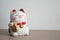 Maneki neko lucky cat show text on hand meaning rich on wood table background, select focus