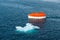 Maneuvering orange lifeboat in water in Arctic waters, Svalbard. Abandon ship drill. Lifeboat training. Man over board drill