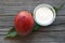 Mango body butter in a glass bowl and fresh ripe organic mango fruit and leaf on old wooden background.