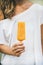 Mango citrus ice cream popsicle in woman`s hand