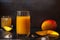 Mango Juice glass with whole and slices fruit on black dark background for veggie tables and healthy habits