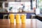 mango lassi takeaway cups in a cafe setting, with a blurred background