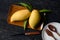 Mango and leaves in wood tray with knife and dish on wood table