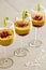 Mango mousse in wine glasses with kiwi and pomegranate seeds