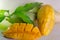 Mango nicely cut with leaf on wooden background (Other names of