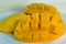 Mango nicely cut on the plate on wooden background (Also known a