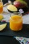 Mango and orange detox juice over black slate board.