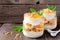 Mango, pineapple parfaits in mason jars on rustic wood