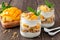 Mango, pineapple parfaits in mason jars on rustic wood