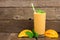 Mango smoothie with mint and straw against rustic wood