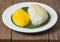 The mango sticky rice with peeled split mung bean on white plate