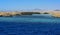 A mango tree among coral reefs in the form of mountains and rocks against the blue sky and clear sea water.