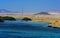 A mango tree among coral reefs in the form of mountains and rocks against the blue sky and clear sea water.