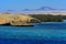 A mango tree among coral reefs in the form of mountains and rocks against the blue sky and clear sea water.