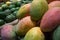 Mangoes in the foreground and avocados in the background