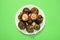Mangosteen fruit in white plate on green background, top view. Many fresh purple mangosteens