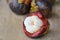 Mangosteen tropical fruit peel out on wooden plank