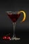 Manhattan cocktail a classic mixed drink aperitif with cherries and orange peel on black background.