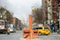 Manhattan, New York, USA - December 26, 2019: Typical vew of street in East Village with local, cars, apartment bulidings, shops,