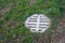 A manhole cover in the middle of the green